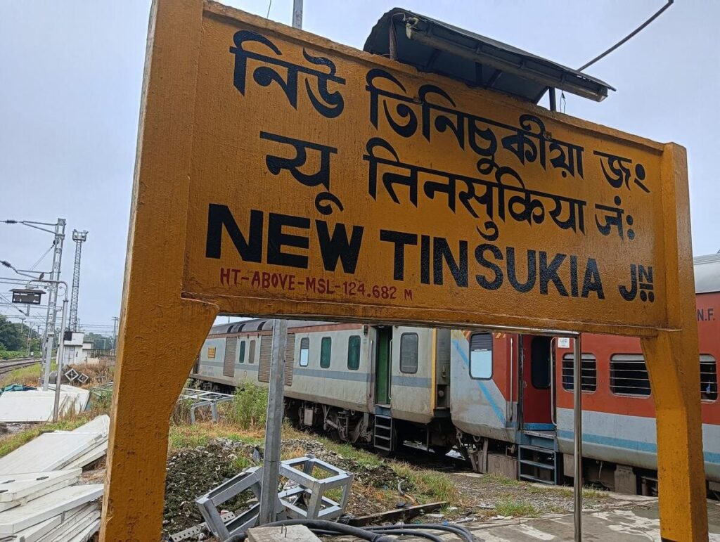 New Tinsukia railway station signboard with train coaches in the background in Assam