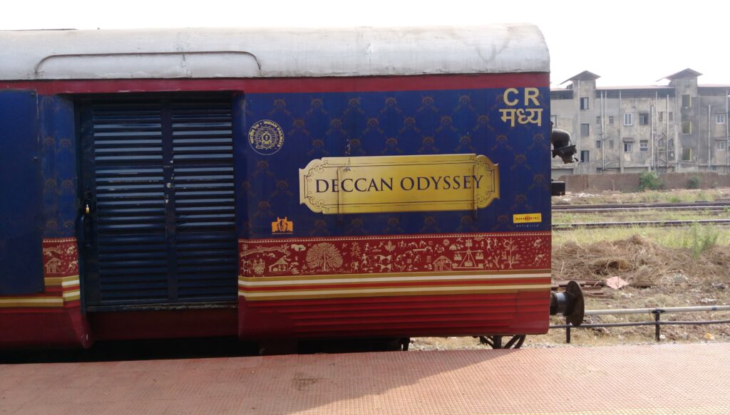 Deccan Odyssey luxury train coach exterior with blue and red royal design at railway station