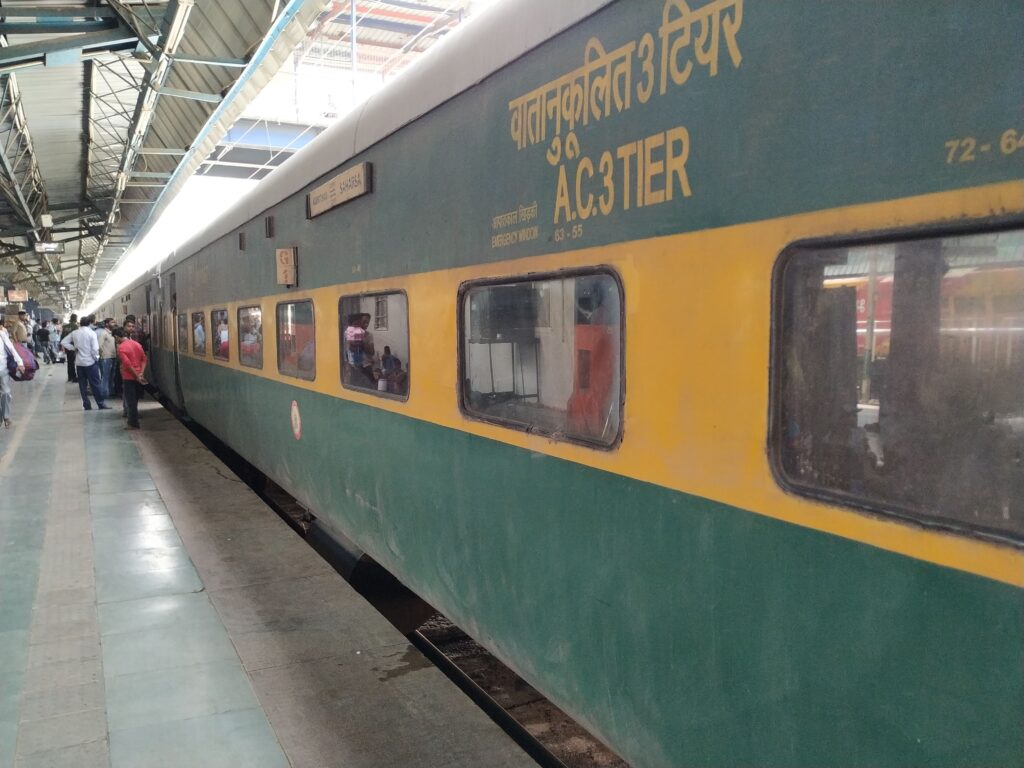 Indian Railways AC 3 tier coach at platform showing long distance train travel