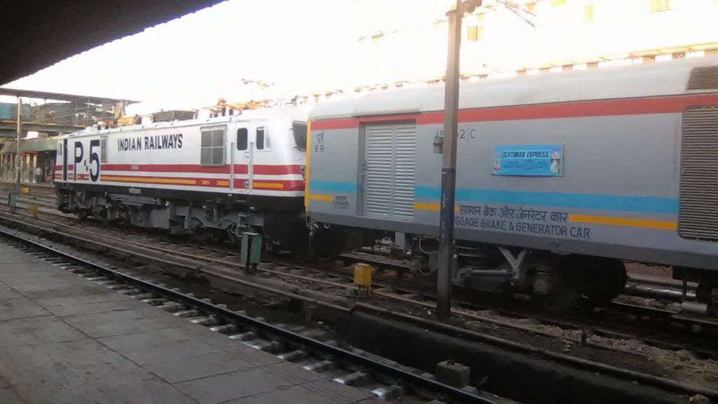 Indian Railways WAP electric locomotive with passenger train coach standing at a railway station platform