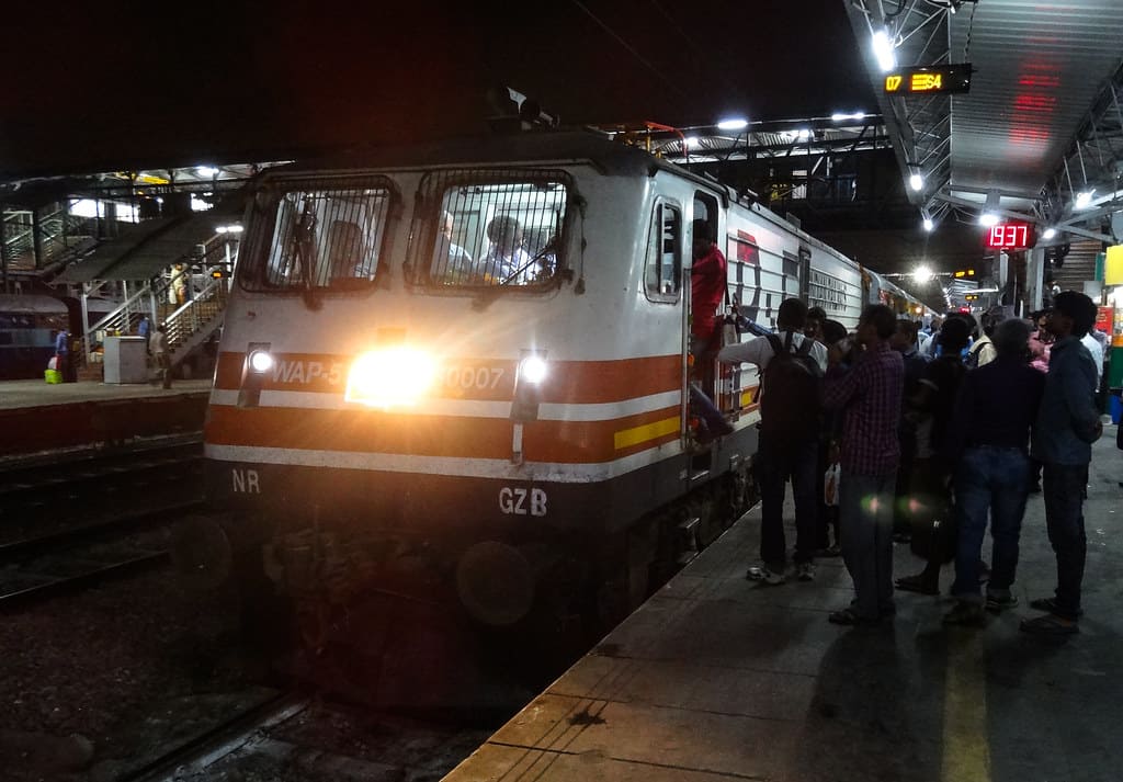 Indian Railways electric locomotive WAP engine at platform with passengers boarding at night