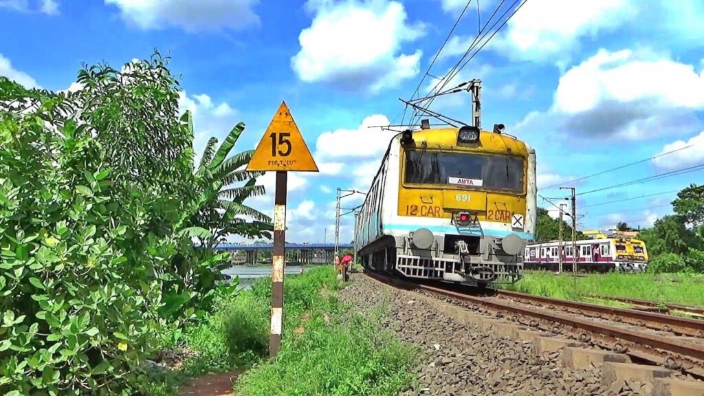 Indian suburban EMU train near Amta route with speed limit sign showing 15 km/h on track
