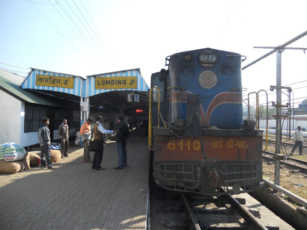 Diesel locomotive at Lumding Junction railway station with passengers on the platform in Assam