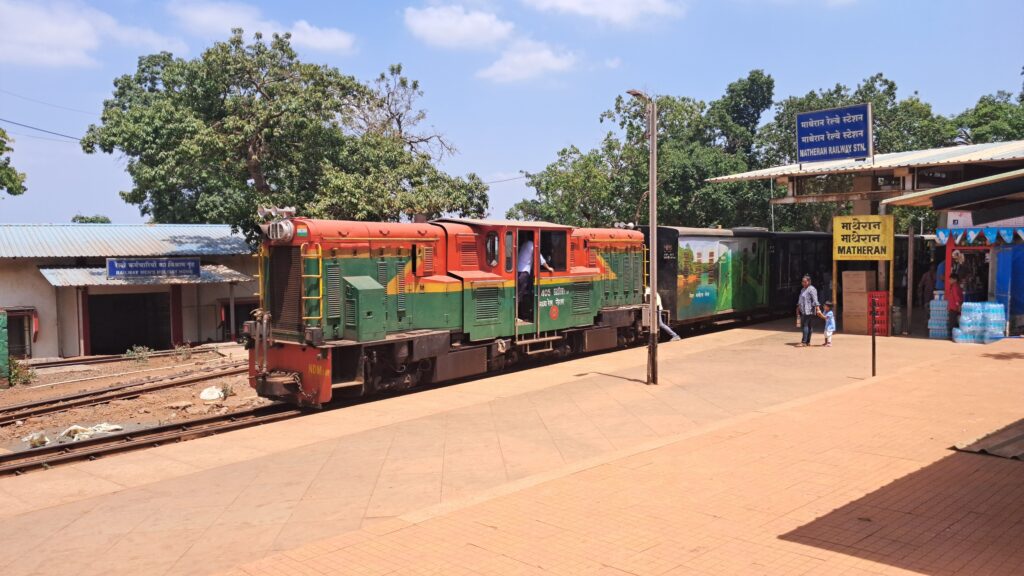 Matheran toy train at station platform with narrow gauge coaches and passengers