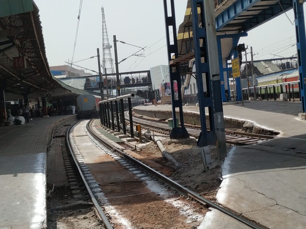 Indian railway station platform with multiple tracks and trains showing busy travel routes with high passenger demand
