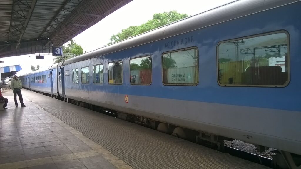 Indian Railways AC chair car coach at platform showing comfortable seating train