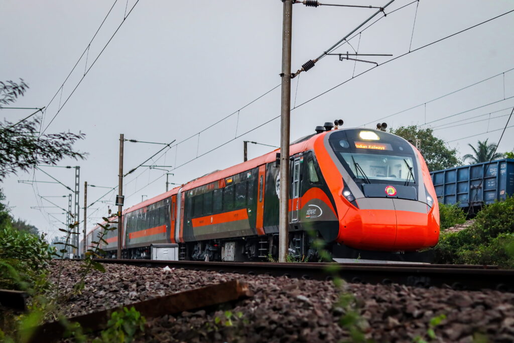 Vande Bharat Express train running on Indian Railways track with modern design and overhead electric lines