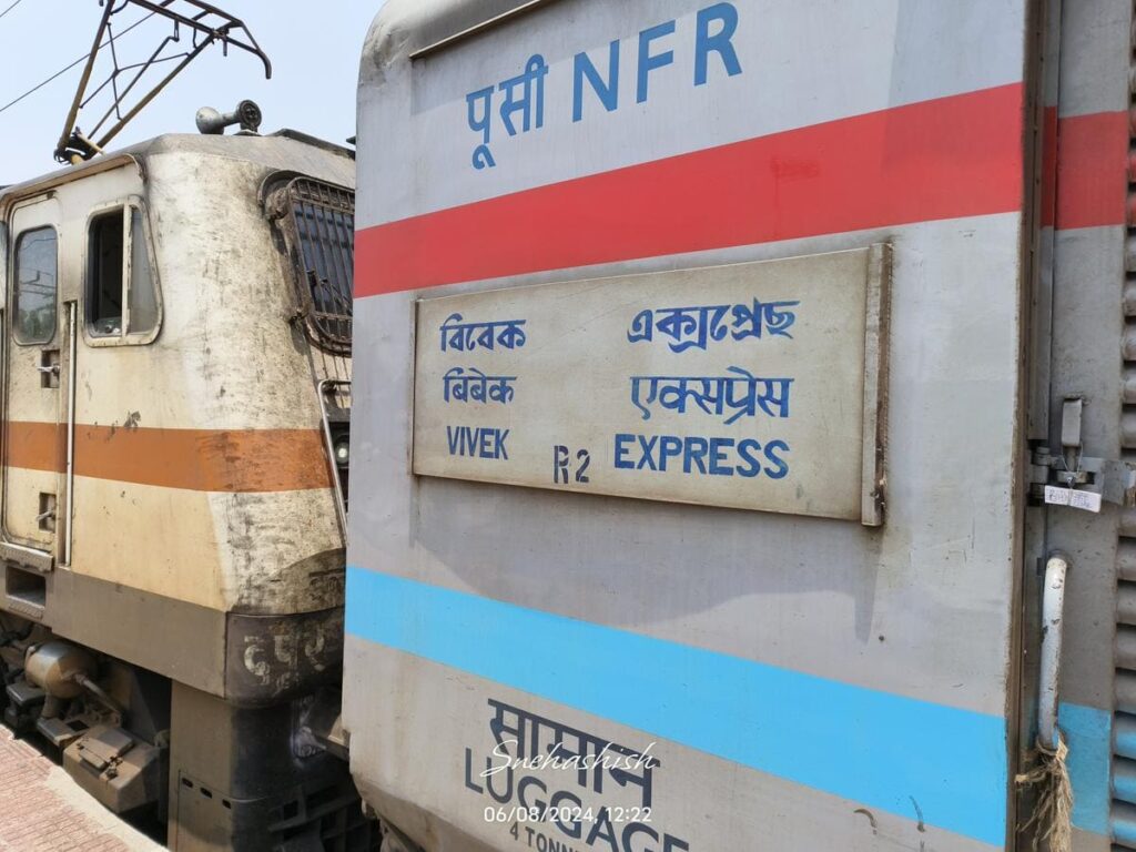 Vivek Express train coach with route board and locomotive visible at railway station